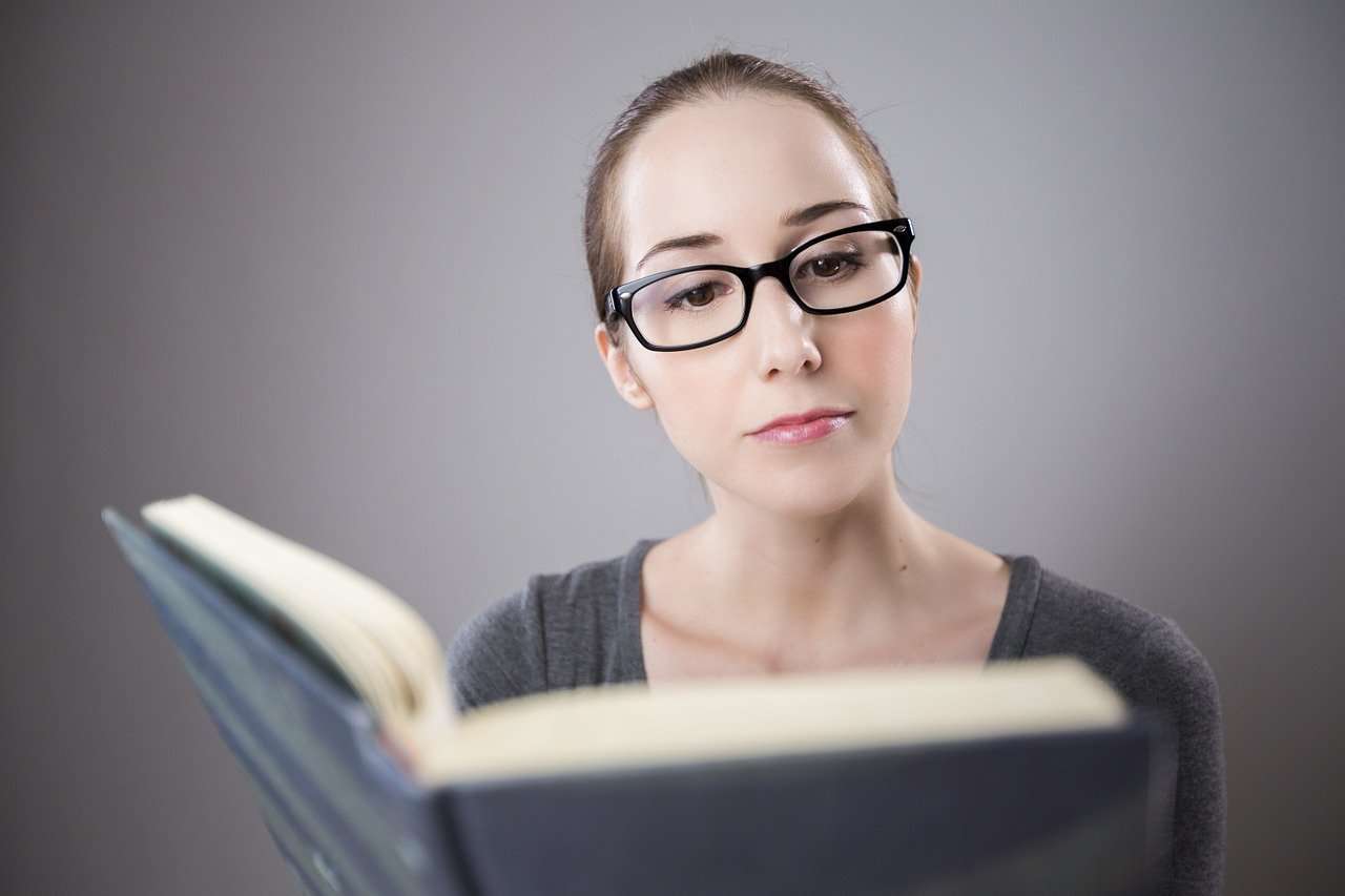 Woman reading a book on business loan terminology