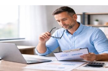 business owner reviewing financial documents while evaluating short-term financing decisions and cash flow impact