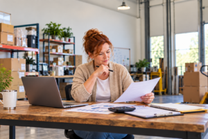 Business owner reviewing borrowing base line of credit documents in a warehouse office