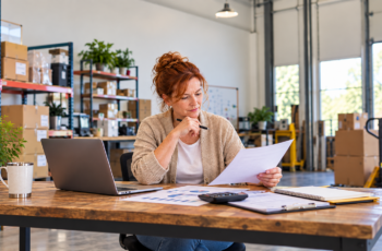 Business owner reviewing borrowing base line of credit documents in a warehouse office